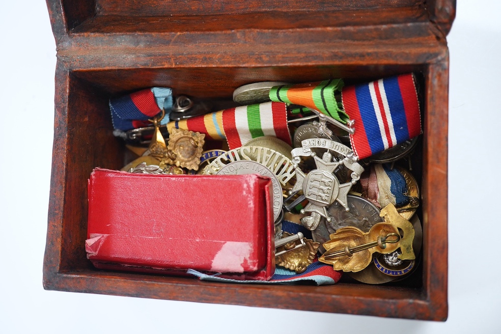 An assortment of WWI interest and other medals and related matter to include badges and brooches, some with enamel, housed in a domed box, together with two swagger sticks, Condition - mostly fair